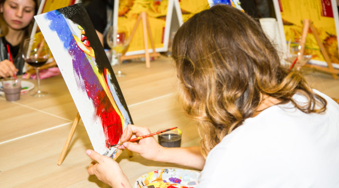 „Nie nur ein Eisen im Feuer haben!“ A group of Young individuals enjoying paint n sip activities outdoor. High quality photo
