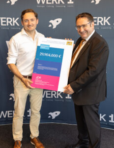 Bayerns Wirtschaftsstaatssekretär Tobias Gotthardt (r.) übergibt den Förderbescheid an WERK1-Geschäftsführer Dr. Robert R. Richter (c) WERK1