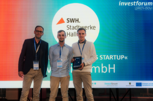 Benjamin (v. r.) und Konstantin Rolf von der Riventic GmbH aus Magdeburg freuen sich über die Auszeichnung als "Überzeugendstes Startup" des Investforum Pitch-Day 2026. Überreicht wurde der Preis von Andreas Haschke von den Stadtwerken Halle, die das Preisgeld stifteten.